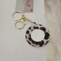 Détail d'un porte-clés miroir portable à imprimé léopard avec une finition dorée élégante. - Style Rond / Beige