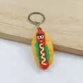 Detail view of a colorful cartoon hot dog keychain with a cute smiling face and sauce - Sausage Pendant