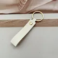 Elegante llavero de cuero PU crema con un anillo dorado pulido para llaves de coche y bolsos - Blanco