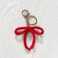 Porte-clés nœud en crochet rouge fait main avec perle délicate et anneaux dorés - Rouge