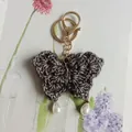 Porte-clés papillon fait main au crochet en fil gris foncé avec des perles blanches - Noir
