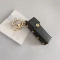 Étui à rouge à lèvres en cuir noir avec boutons dorés et attache porte-clés pratique - Pochette pour Rouge à Lèvres / Noir