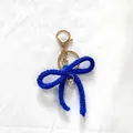 Porte-clés nœud bleu crocheté main avec fermoir mousqueton doré et breloque perle - Bleu Saphir