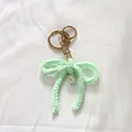 Handmade mint green crocheted yarn bow keychain with a delicate pearl charm accessory - Green