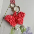 Cute handmade red crocheted butterfly keychain featuring teardrop pearl charms for bags - Coral