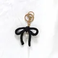 Elegant handmade black crochet bow keychain featuring a delicate white pearl charm pendant - Black