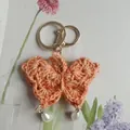 Handmade crochet butterfly keychain in coral orange finish with white pearl charms - Orange