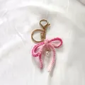 Handmade pink and white gradient crocheted wool bow keychain featuring a delicate pearl - Gradient Pink