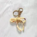 Elegant handmade crochet bow keychain with pearl pendant in pale yellow for bag decor - Gradient Yellow