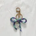 Handmade multicolored crochet bow keychain with gold hardware and pearl charm - Gradient Purple Blue