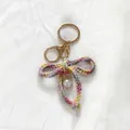 Hand-crocheted colorful yarn bow keychain with pearl charm for cute bag decoration - Gradient Pink Yellow