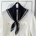 Elegant black pleated scarf with white contrast piping on a white knit top - 60CM / Black