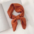 Gros plan d'un foulard en satin orange noué sur un magazine - Couleur caramel / 70cm