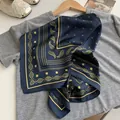 Detailed close-up view of a navy blue paisley silk scarf draped on a grey shirt - Starry Sky Paisley - Navy