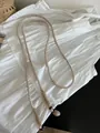 Detailed view of bohemian cotton woven belt with beads and stone accents on a dress - Woven Beaded Style / Off White