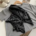 Close-up of elegant black paisley silk scarf draped over a grey t-shirt fashionably - Starry Sky Paisley - Black