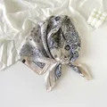Detailed view of a navy blue paisley pattern silk scarf elegantly knotted on white fabric - White Paisley