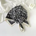 Detailed macro view of navy paisley pattern on high-quality silk scarf fabric - Classic Black Aesthetic