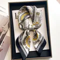 Luxurious navy blue paisley silk scarf with gold details displayed on a magazine - Totem Paisley