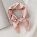 Vue détaillée d'un foulard en satin rose noué avec élégance sur un livre ouvert - Rose Clair / 70cm