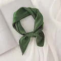 Gros plan détaillé d'un foulard en soie vert foncé noué avec élégance pour le cou - Vert forêt / 70cm