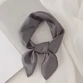 Détail d'un foulard en soie gris anthracite noué posé sur un fond très minimaliste. - Gris / 70cm