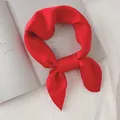 Gros plan d'un foulard en soie rouge vif noué avec élégance sur un magazine - Rouge de Chine / 70cm