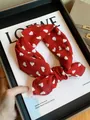 Red cotton square scarf with cute white heart patterns styled as a headband on a magazine - Red Heart