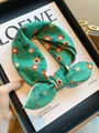 Soft green cotton scarf with orange floral pattern in a knotted square bandana style - Green Paisley Sunflower