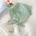 Dettaglio di un foulard a triangolo in cotone a quadretti verdi e bianchi con lacci - 45x45x62cm / Quadri Verde (4chic)