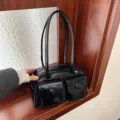 Vintage black glossy shoulder bag with double front pockets and round buttons - Black