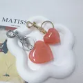 Pair of glittery peach heart-shaped keychains presented in a decorative white tray - L / Pink