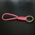Durable hand-woven pink paracord keychain featuring a stylish gold-tone metal ring - Pink