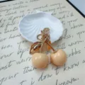 Cute glossy cream cherry keychain with golden metal stem fruit bag charm accessory - Milk Yellow