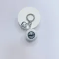 Gothic realistic eyeball keychain with silver heart pendant on white display stand. - White Ball Grey Eye