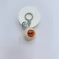 Gothic horror eyeball keychain with silver heart charm and orange slitted iris design - Cream Ball Red Eye