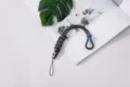 Grey braided paracord wrist strap with blue adjustment slider and quick release - Braided Style (Buckle + Button) / Gray