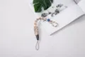 Durable woven paracord phone wrist strap with blue adjustable slider and quick release buckle - Braided Style (Buckle + Button) / Cream Pattern