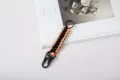 Hand-woven orange and black paracord survival keychain featuring a sturdy metal eagle beak clip - Orange Black