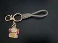 Hand-woven khaki wrist strap keychain with a traditional cute Maneki-neko lucky cat charm - Camel