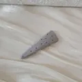 Gros plan d'une pince à cheveux grise à pois sur un tissu blanc texturé élégant - Barrette Triangle à Pois / Bleu gris