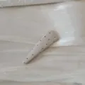 Détail d'une pince à cheveux en tissu blanc crème à pois noirs pour femmes élégantes - Barrette Triangle à Pois / Beige