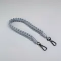 Handgewebter grauer Paracord-Gurt mit robusten Karabinern aus dunklem Metall-Material. - Grau