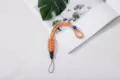 Braided orange paracord phone wrist strap with adjustable buckle and detachable clasp - Braided Style (Buckle + Button) / Orange Patterned