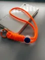 Adjustable orange paracord phone wrist strap with blue buckle detail - Orange Rope + Orange Spring Ring
