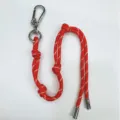 Stylish red braided rope bag charm featuring a silver carabiner and adjustable knots - Red