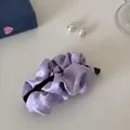 Detailed close-up view of a lavender satin polka dot banana hair clip on a white table - Purple Polka Dot - Ruffled Banana Clip