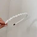 Detailopname van een elegante Franse haarband met witte parels en kristallen kralen - Strass Strik