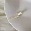 Détail en gros plan d'une pince à cheveux triangulaire crème avec texte fait main - Clip Triangulaire Sans Trace (FJ83071) / Beige
