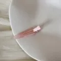 Gros plan d'une pince à cheveux triangulaire rose avec gravure FRANCE Handmade - Clip Triangulaire Sans Trace (FJ83071) / Rose transparent
